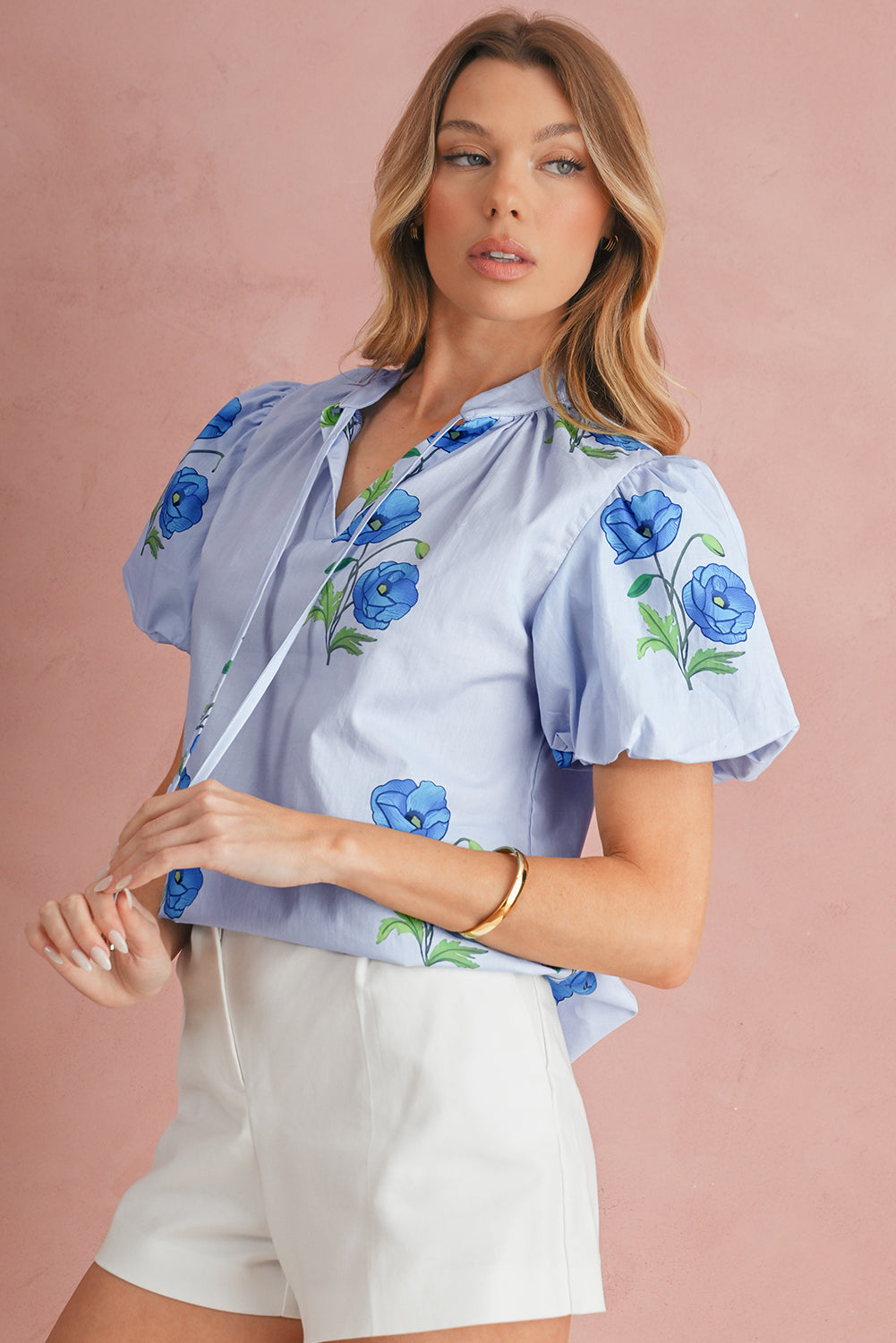 Chemisier bleu ciel à imprimé floral, col noué et manches courtes