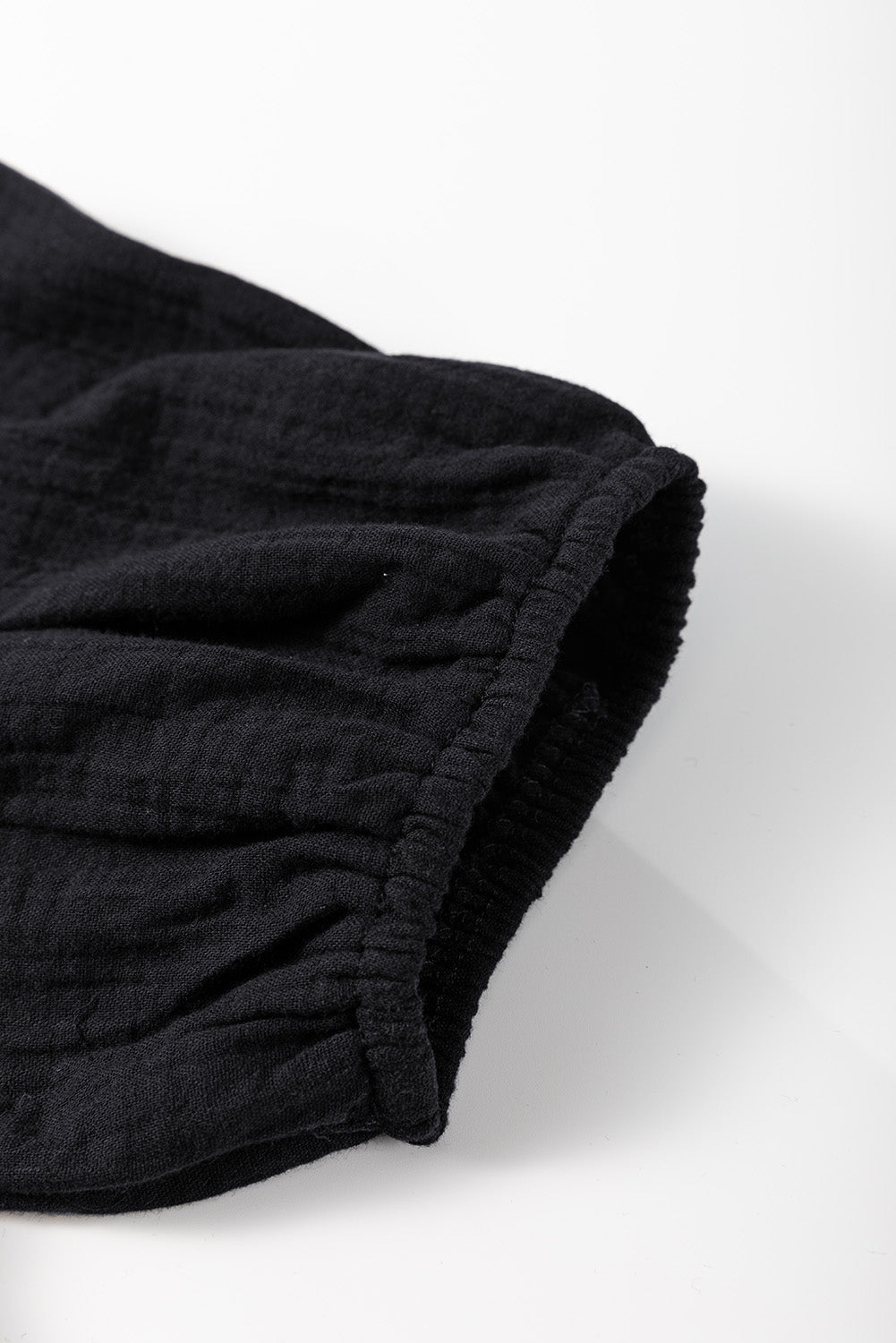 Chemisier noir froissé à col carré crochété — manches courtes à volants, détail crochet