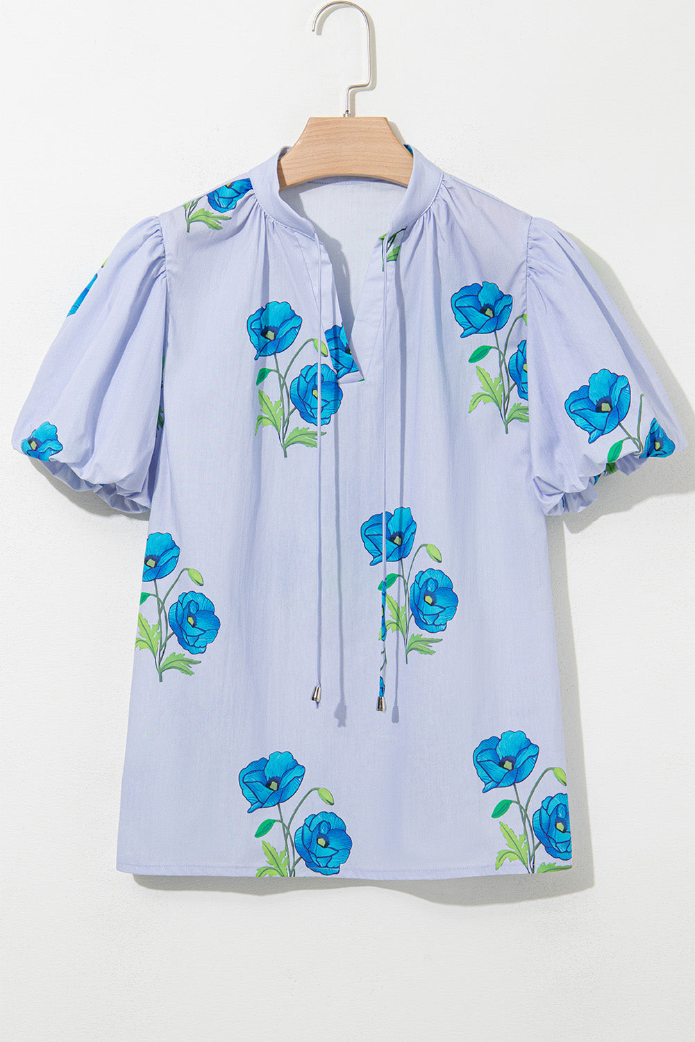 Chemisier bleu ciel à imprimé floral, col noué et manches courtes
