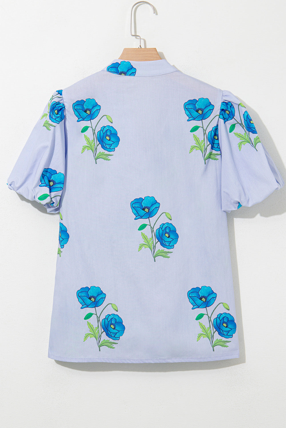 Chemisier bleu ciel à imprimé floral, col noué et manches courtes