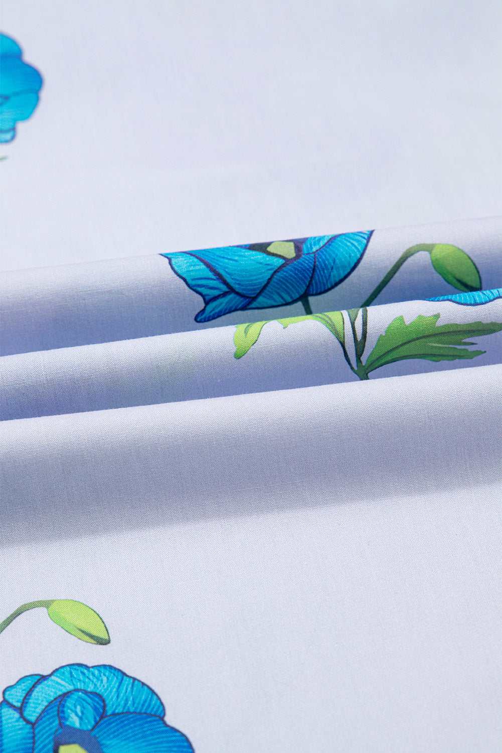 Chemisier bleu ciel à imprimé floral, col noué et manches courtes