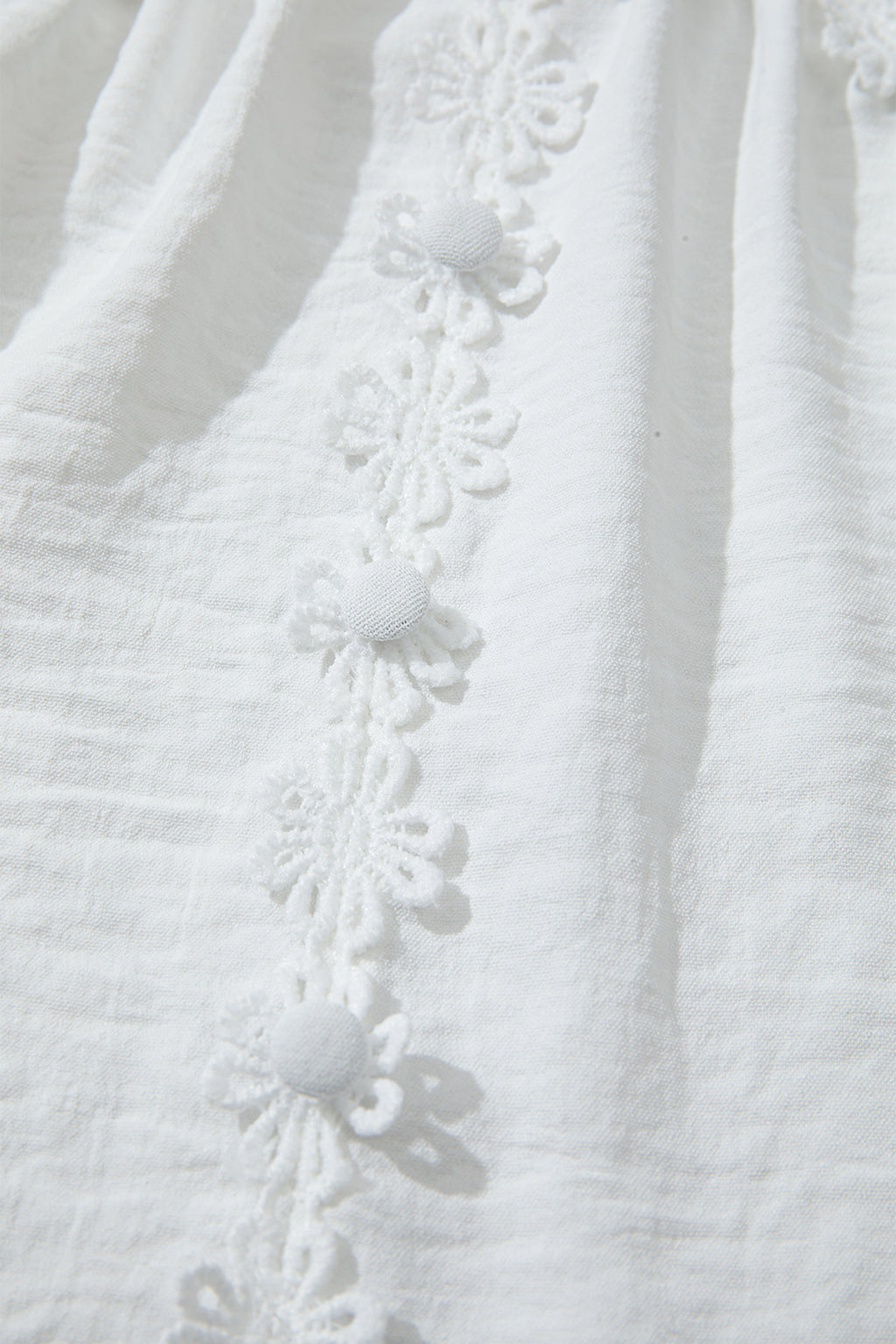 Chemisier blanc en dentelle guipure florale à manches longues bouffantes