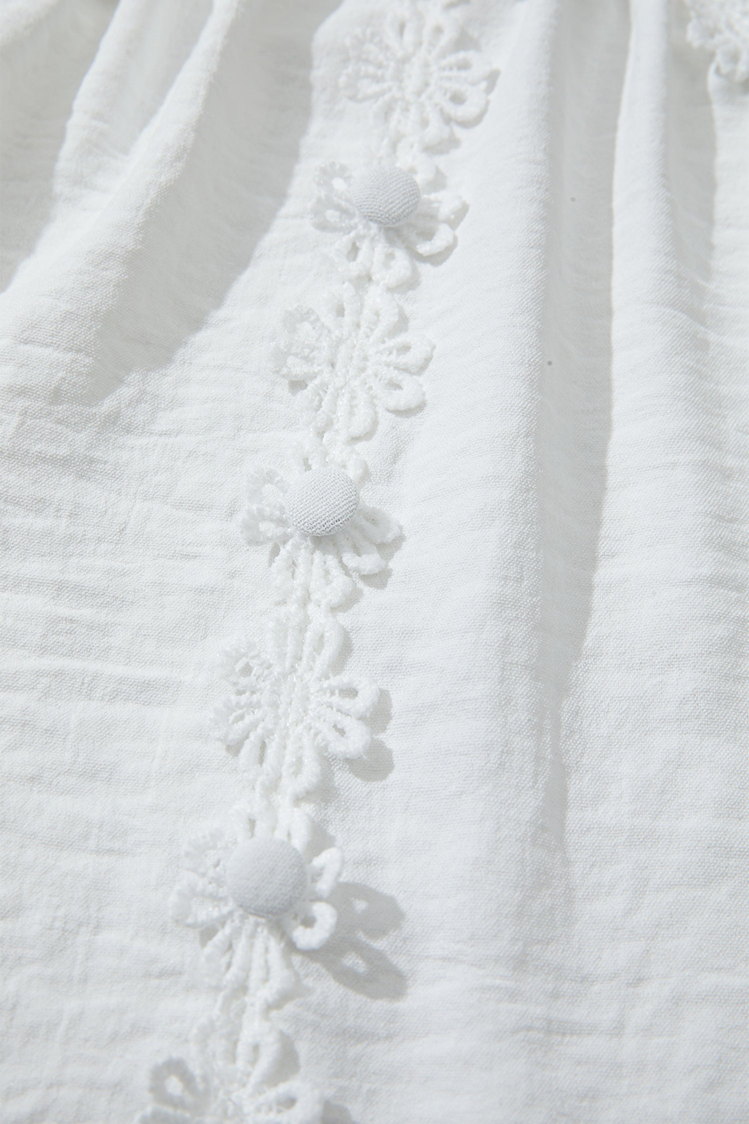 Chemisier blanc en dentelle guipure florale à manches longues bouffantes