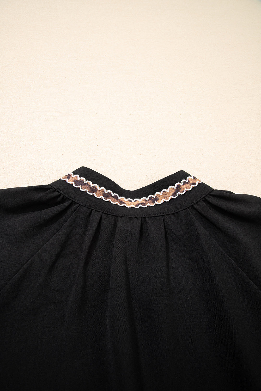 Robe courte noire à col V brodé et manches 3/4 bouffantes