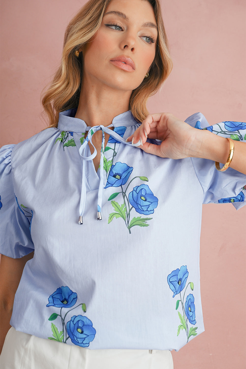 Chemisier bleu ciel à imprimé floral, col noué et manches courtes
